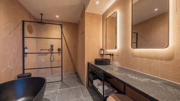 Un baño moderno con una bañera independiente, un tocador con espejo y un box de ducha.