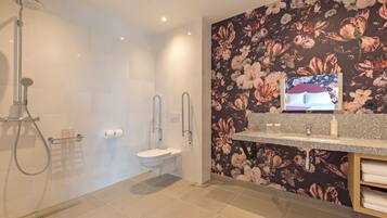Une salle de bain moderne équipée d’une douche, de toilettes et d’un meuble-lavabo.