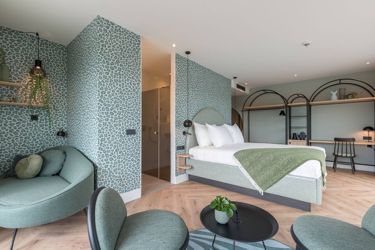Une chambre moderne avec un lit, un canapé, un bureau et une chaise.