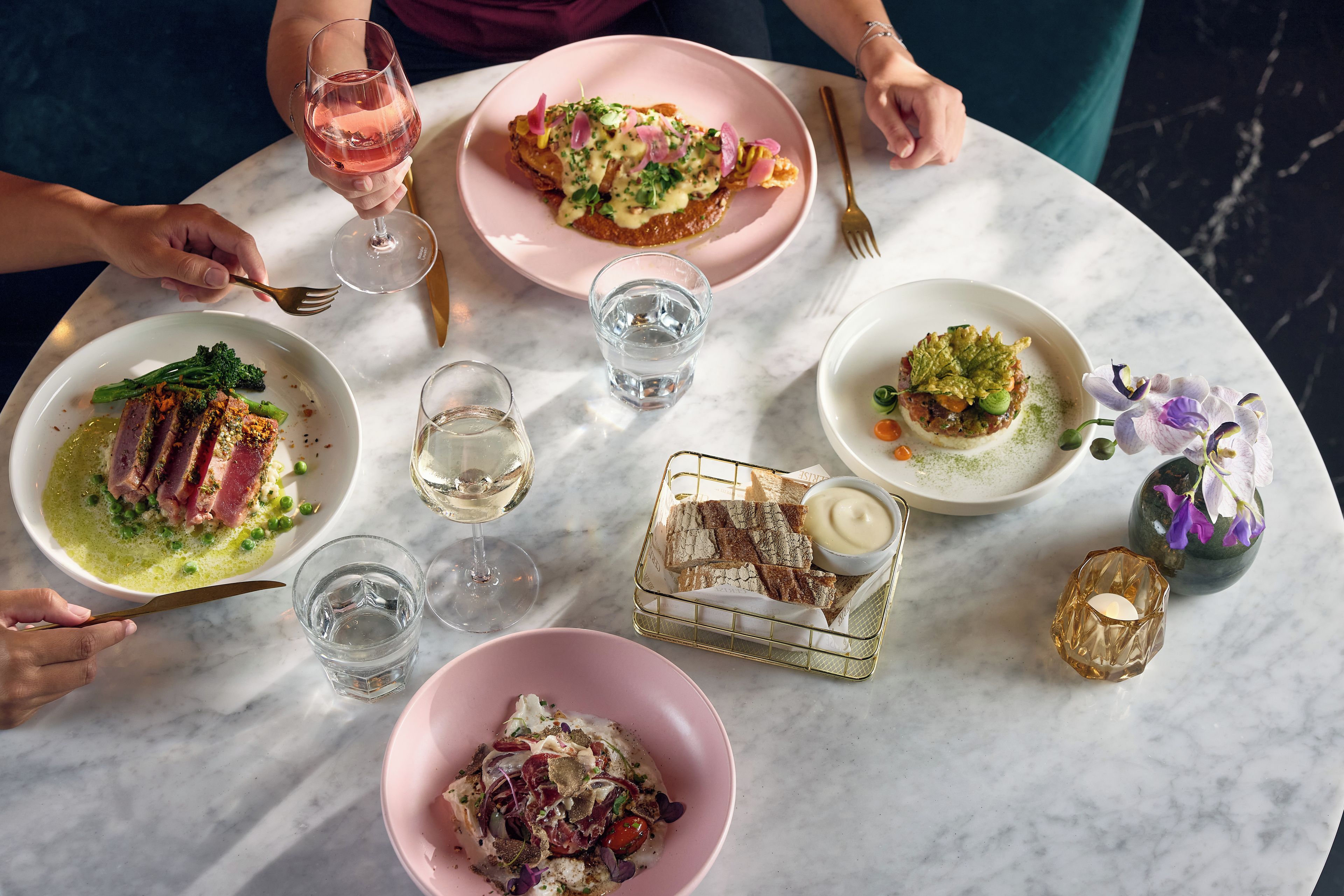A table with various dishes and drinks, suggesting a dining setting.