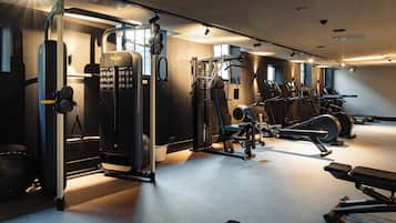 Uma academia com diversos equipamentos de exercícios, incluindo máquinas de peso e esteiras.