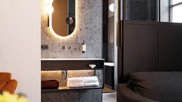 Contemporary bathroom with a large mirror, vanity, and towel rack.