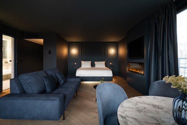 Une chambre d’hôtel moderne, équipée d’un lit, d’un canapé, d’une chaise et d’une petite table.