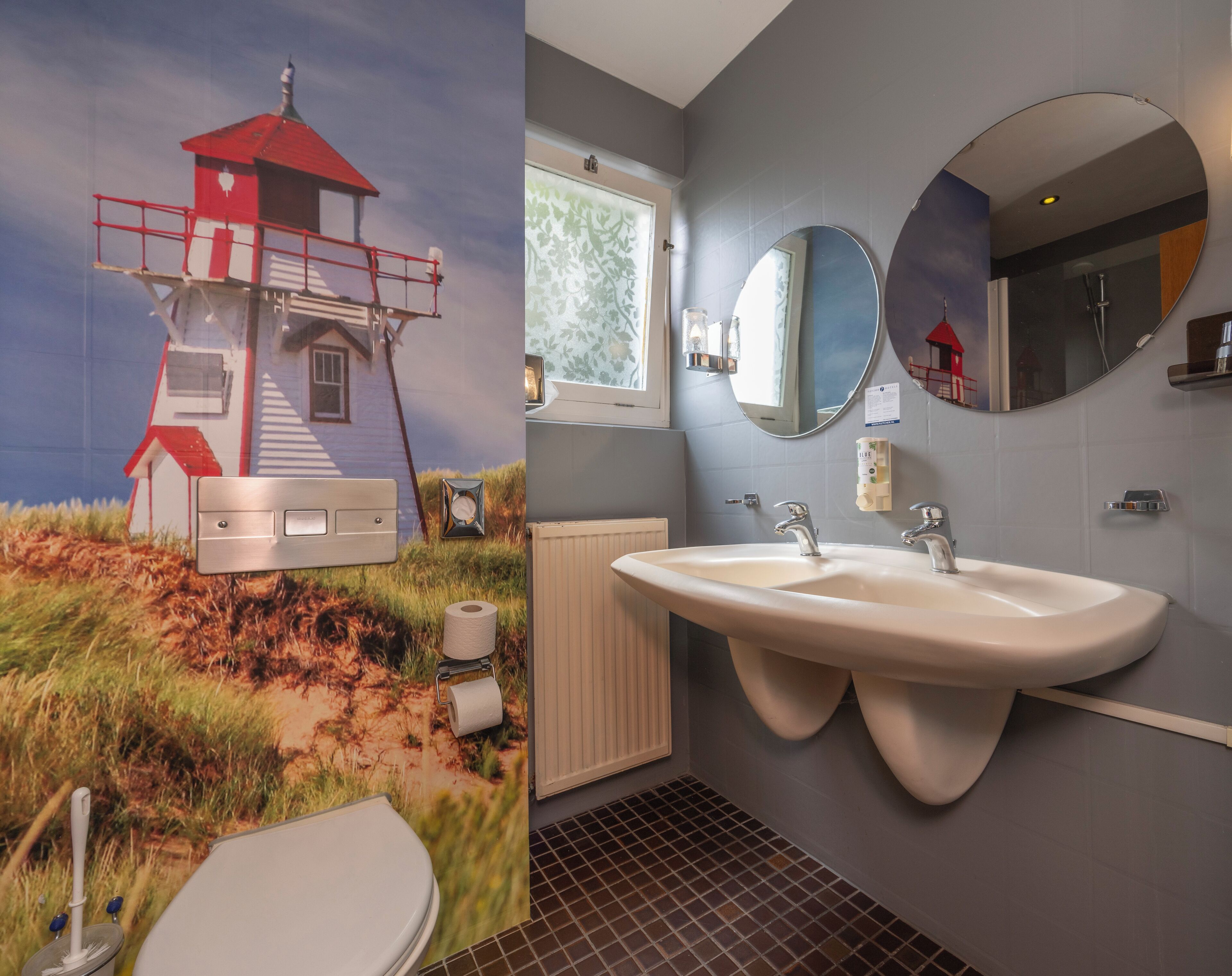 A bathroom with a large sink, two faucets, a mirror, and a toilet.