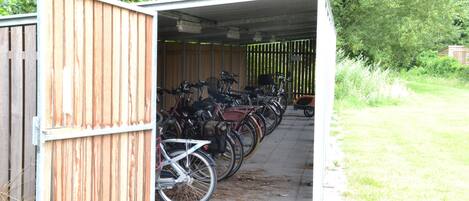Un área techada para guardar bicicletas, con varias bicicletas estacionadas adentro.
