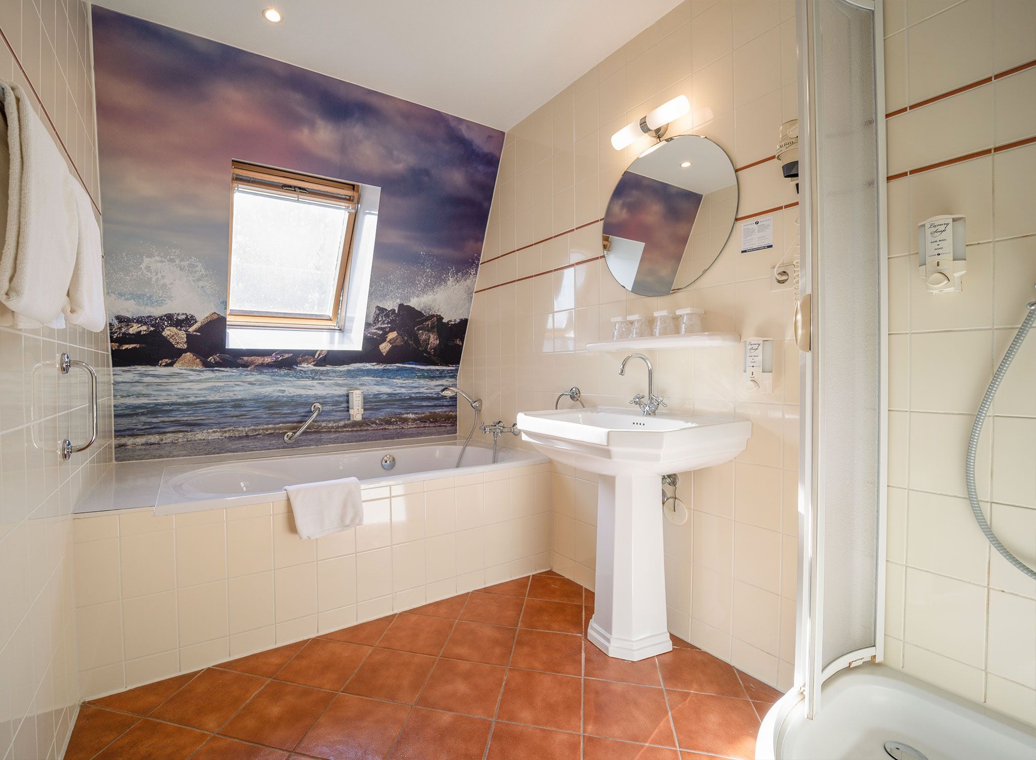 A bathroom with a bathtub, a sink, a shower, and a large window.