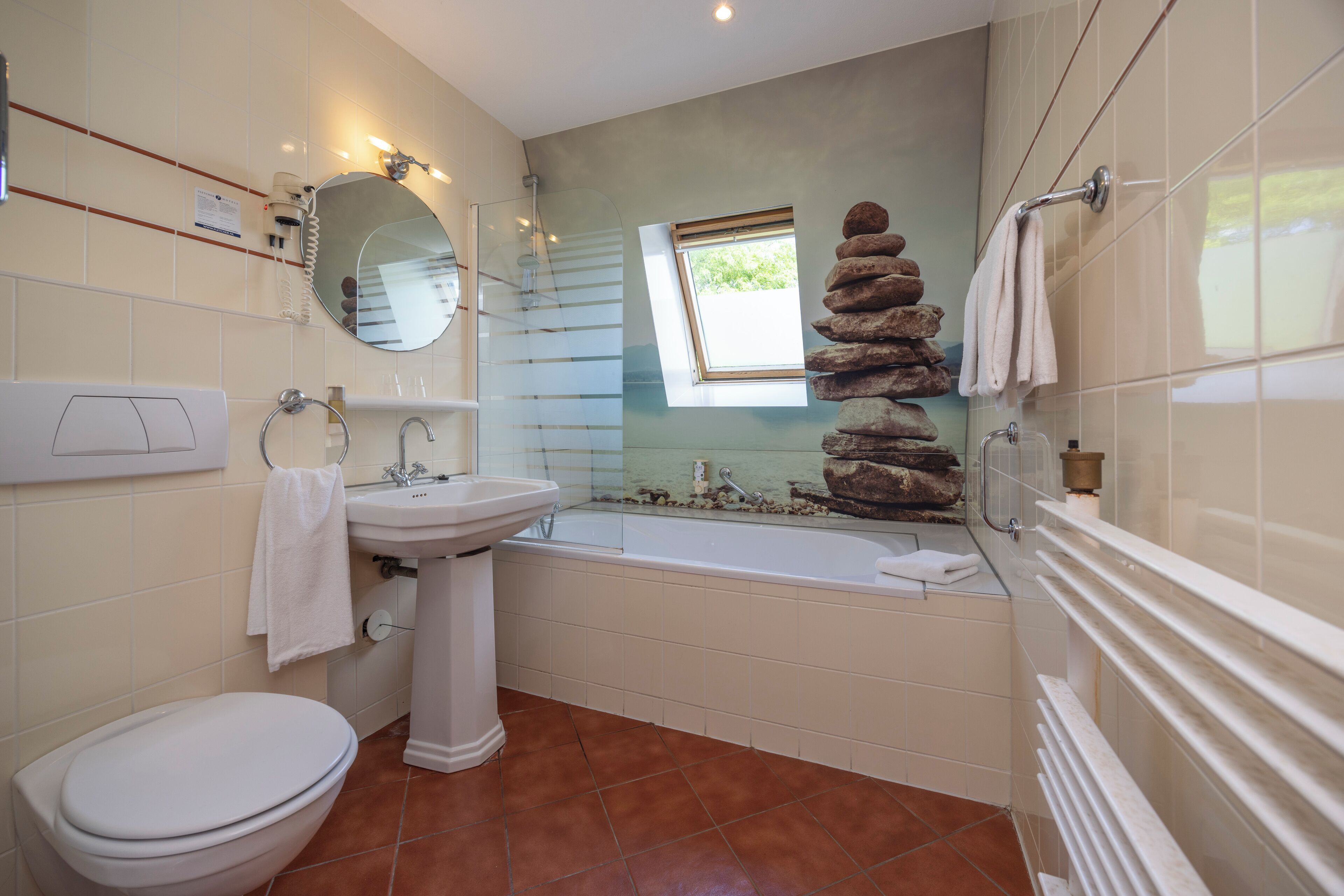 Un baño con inodoro, lavamanos y bañera.