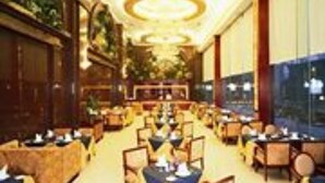 A spacious hotel lobby with multiple dining areas, elegant chandeliers, and large windows offering views. - XinHai JinJiang Hotel Wangfujing (Beijing)