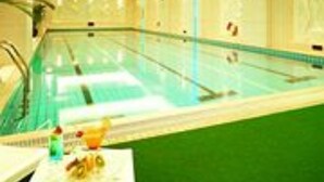 A swimming pool with clear water, surrounded by walls and a ceiling with recessed lighting. - XinHai JinJiang Hotel Wangfujing (Beijing)