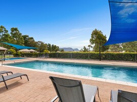 Una piscina al aire libre, tumbonas