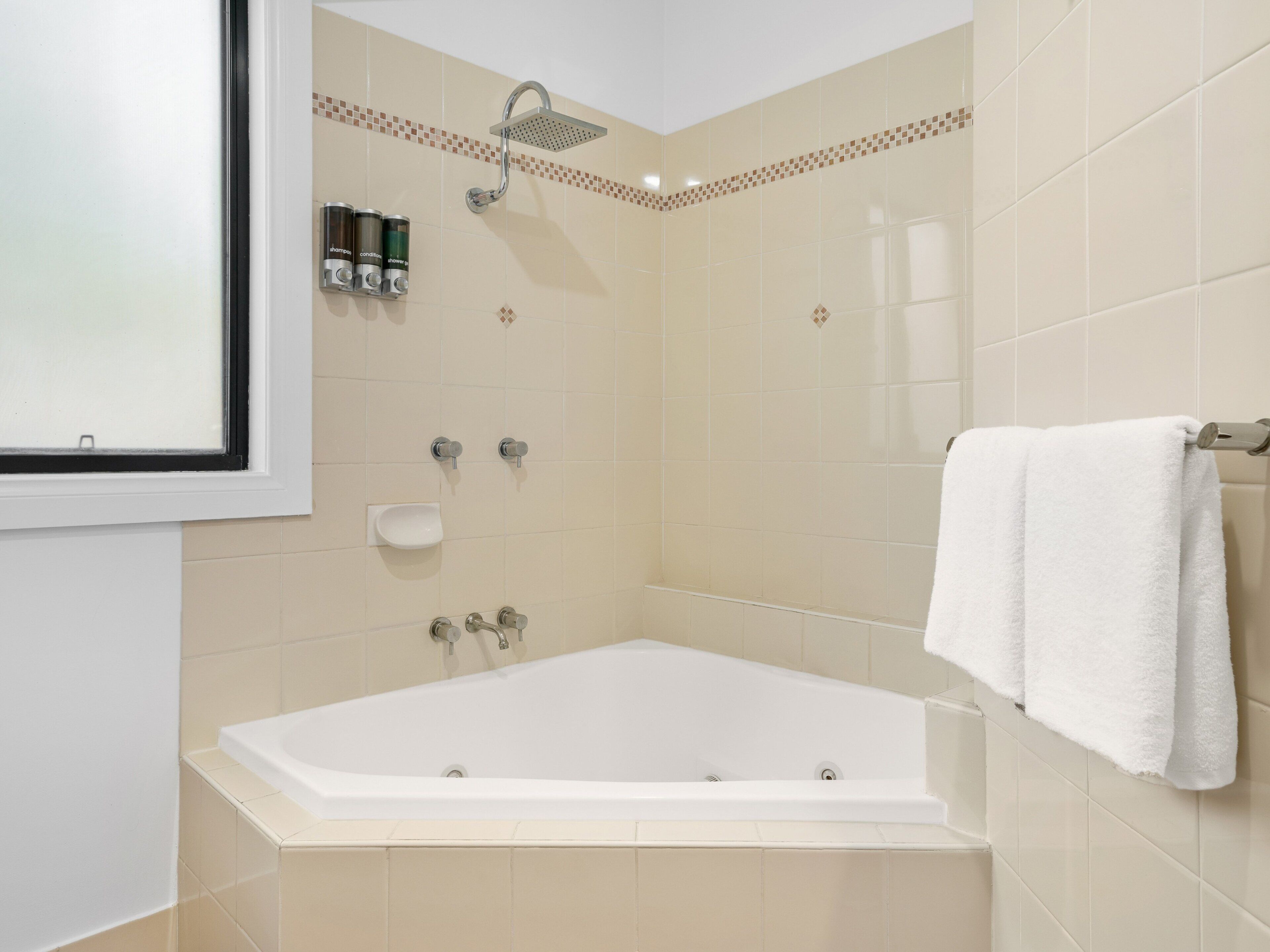 Une salle de bain équipée d’une baignoire, d’une douche et d’un porte-serviettes.