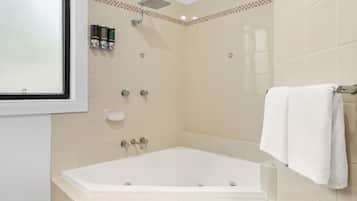 A bathroom with a bathtub, a showerhead, and a towel rack.