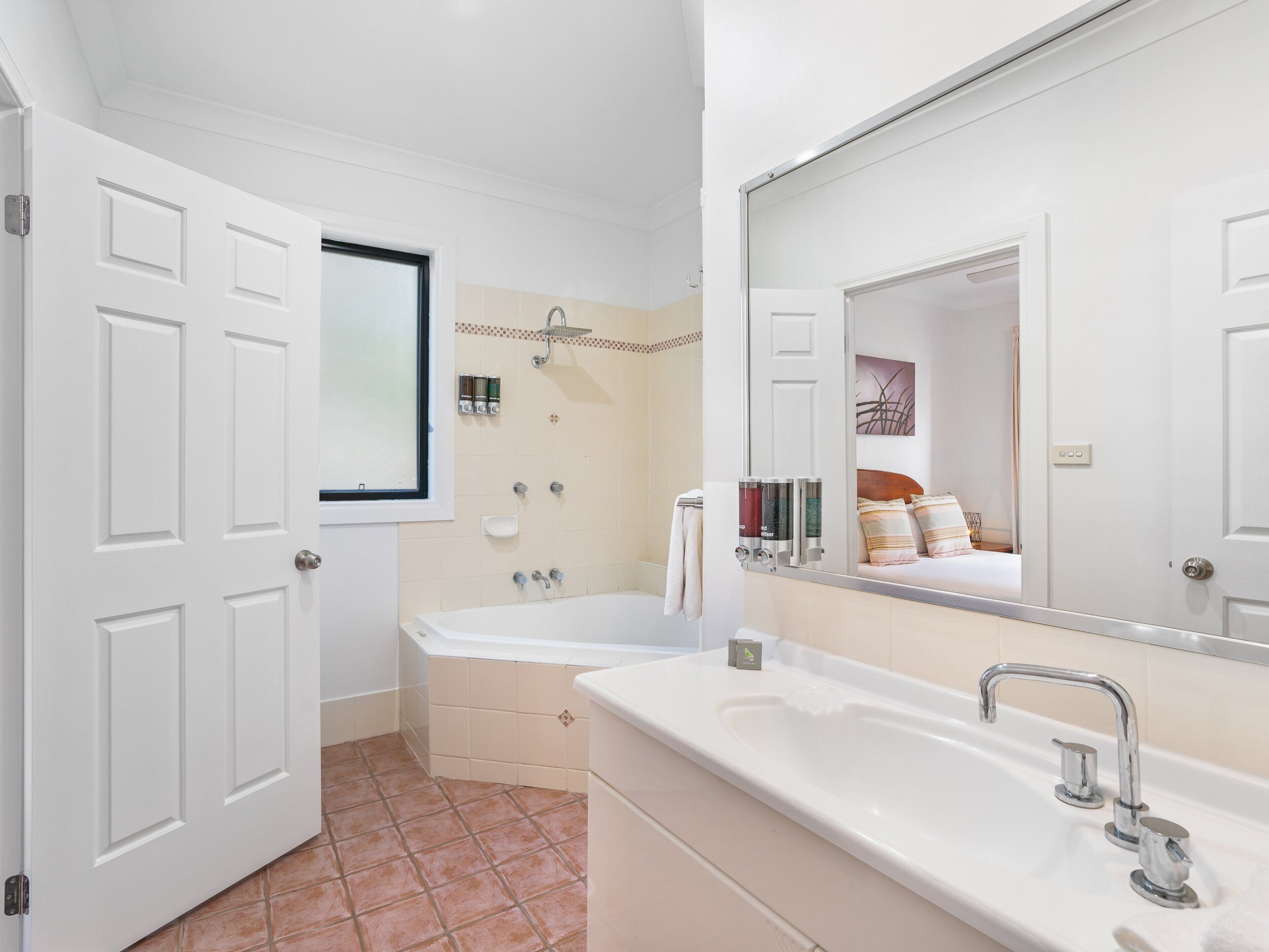 Une salle de bain avec deux lavabos, une douche et un grand miroir.
