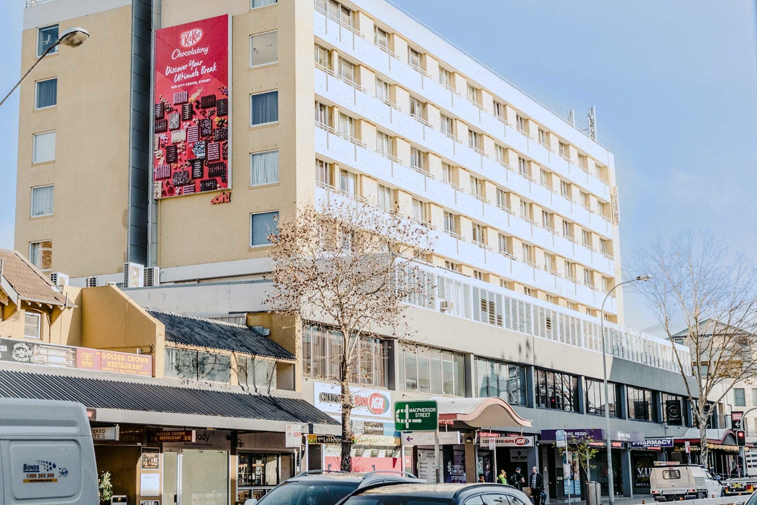 A multi-story hotel with a prominent sign for a chocolate shop on the facade.