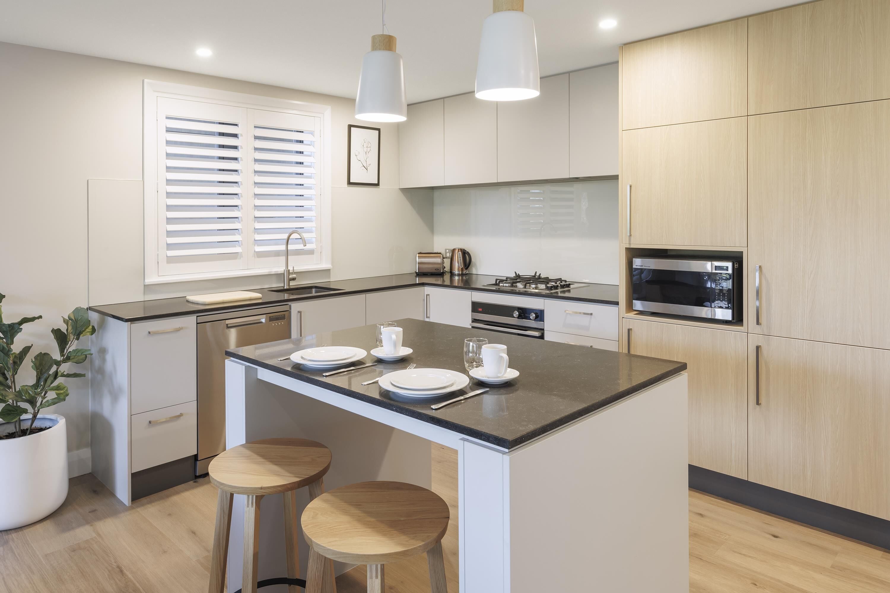 A modern kitchen with a central island, white cabinetry, and stainless steel appliances.