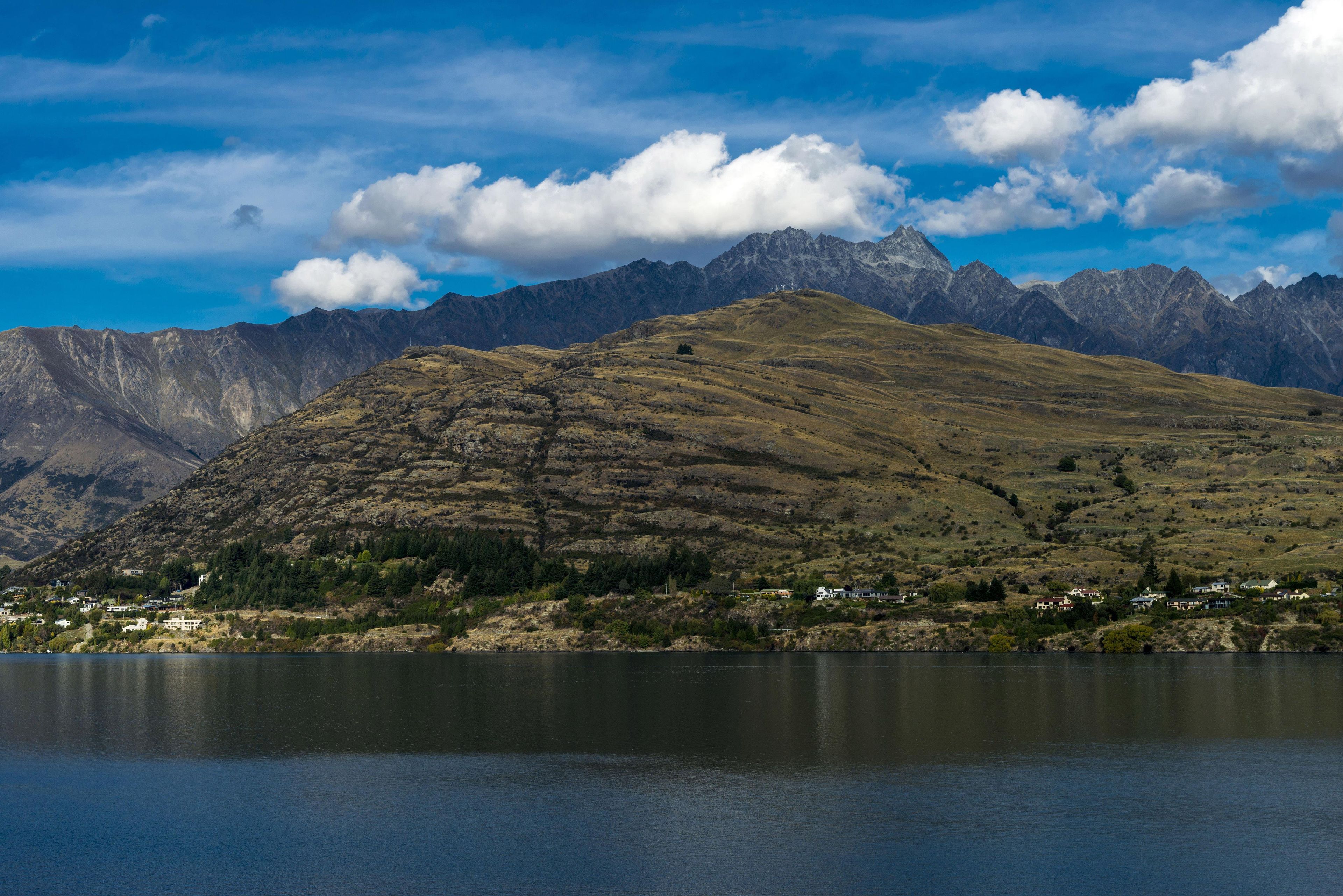Un paysage montagneux avec un lac au premier plan et une chaîne de montagnes en arrière-plan.