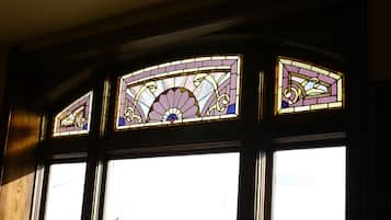 A stained glass window with floral designs and a fan motif.