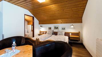 Un dormitorio con techo de madera, una cama con cabecera, mesitas de noche e iluminación en la pared.