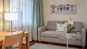 A living room with a sofa, a glass coffee table, a lamp, and a painting on the wall. - Hotel Löwen (Appenzell)