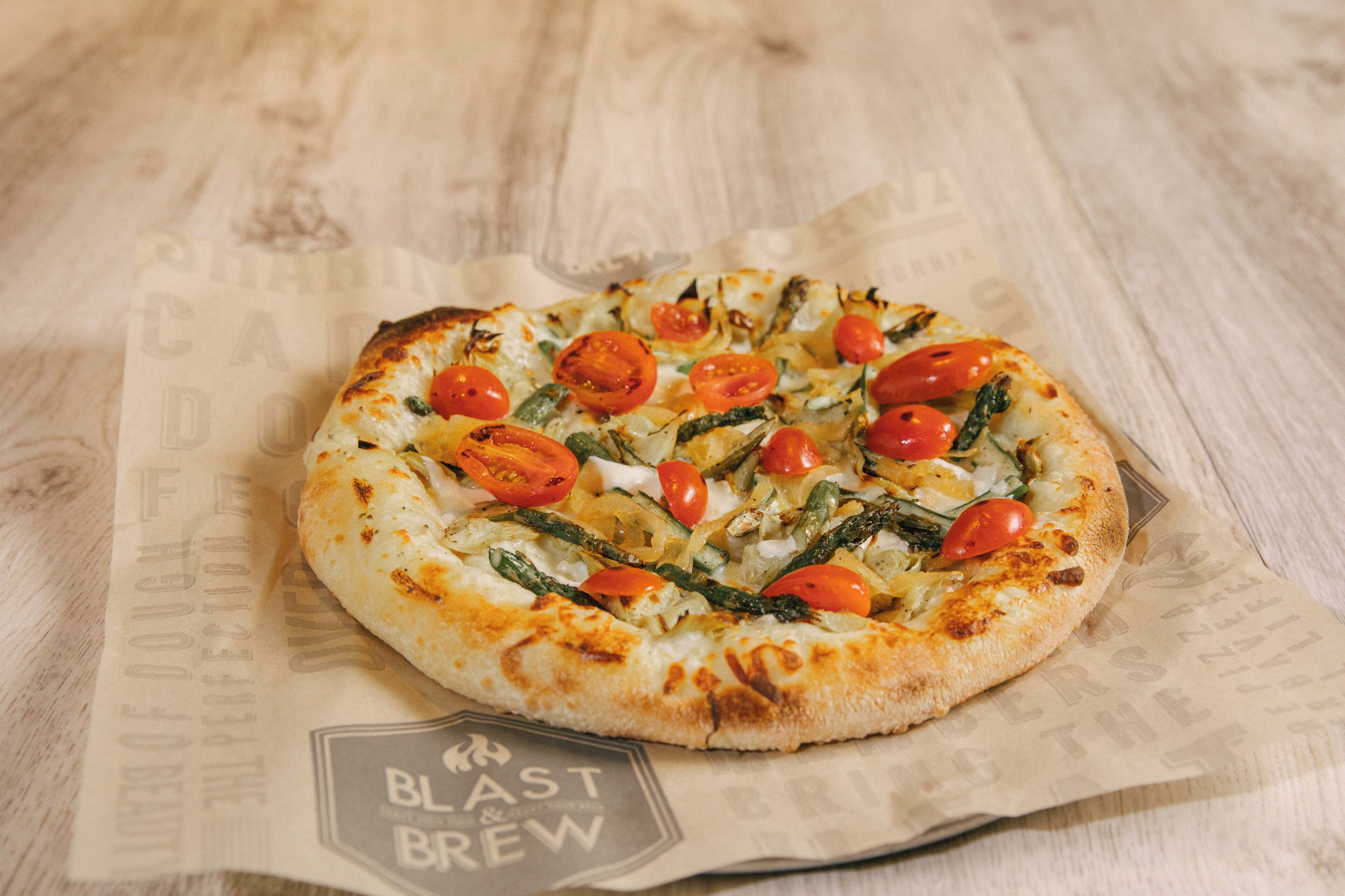 Una pizza sobre una mesa de madera, con un papel debajo.
