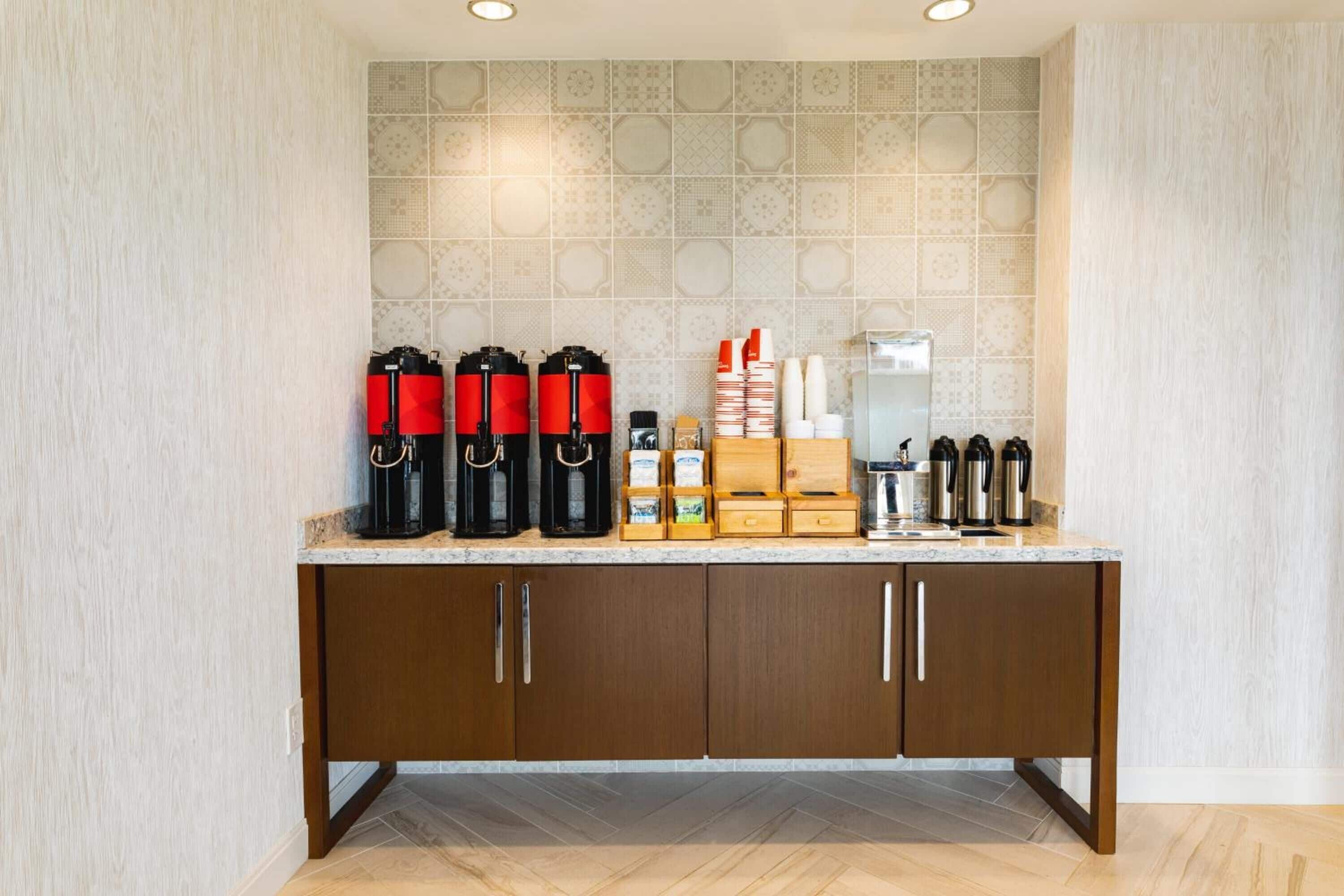 A kitchen area with a countertop, cabinets, and a tiled backsplash.