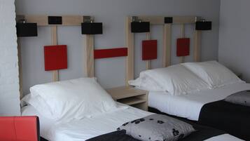 Een hotelkamer met twee bedden, elk voorzien van witte beddengoed en hoofdborden in zwart en rood.