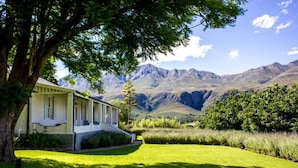 A house with a front porch, a well-maintained lawn, and a mountain backdrop.