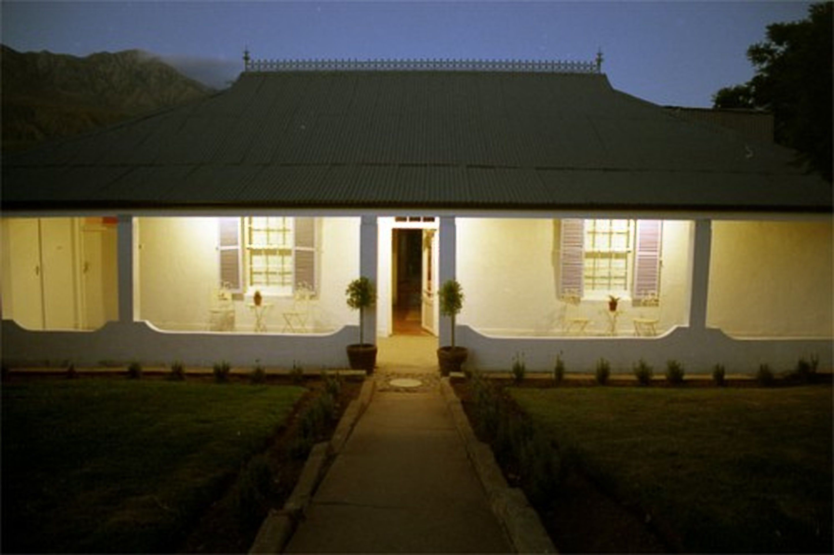 A two-story house with a central entrance, a covered porch, and a well-maintained lawn.