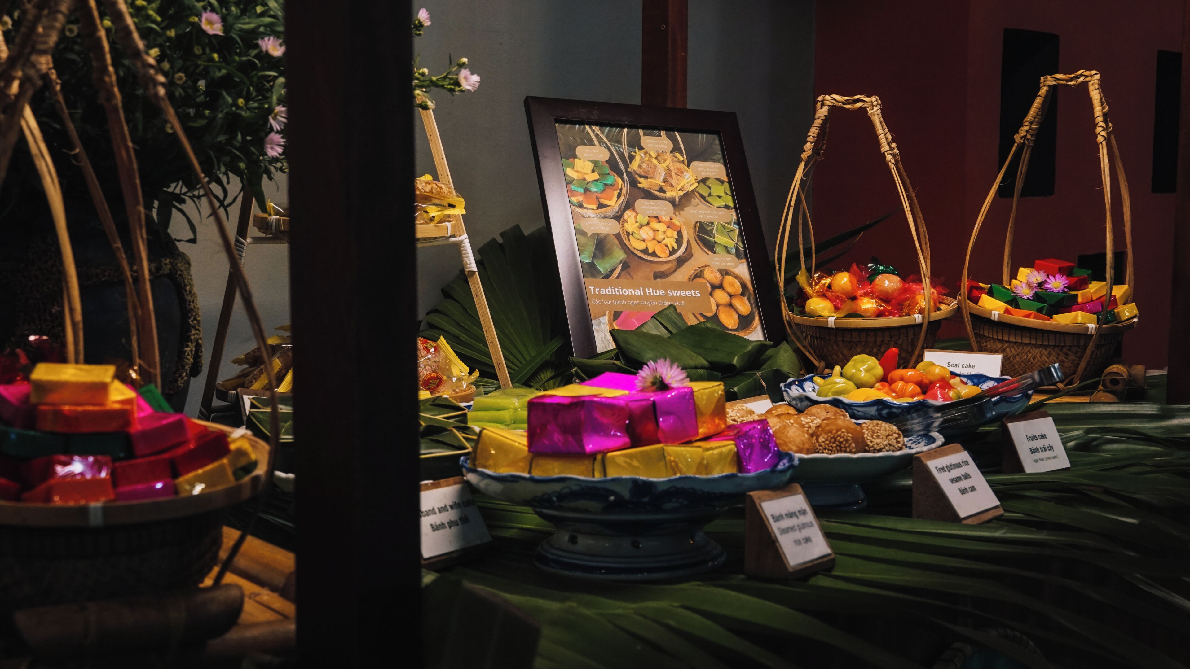 A display of traditional Hue sweets with baskets and labels.