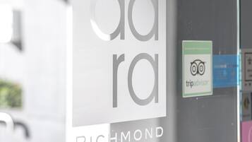 A sign for Aldara Hotels & Apartments in Richmond, with a TripAdvisor logo sticker on the glass door.