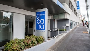 A modern hotel building with a prominent 'ada' sign, a staircase leading to the entrance, and a clear view of the street. - Adara Hotel Richmond (Richmond)