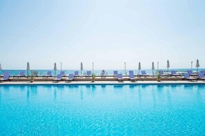 Alberca techada, alberca al aire libre y sombrillas en la alberca