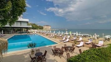 Piscine couverte, piscine extérieure, parasols de plage, chaises longues