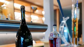 A bar area with a bottle of Duplin Millennial wine, a glass of red wine, and a small potted plant on the counter.