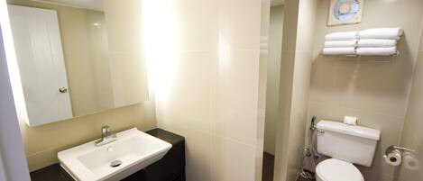 A bathroom with a white sink, a toilet, and a mirror.