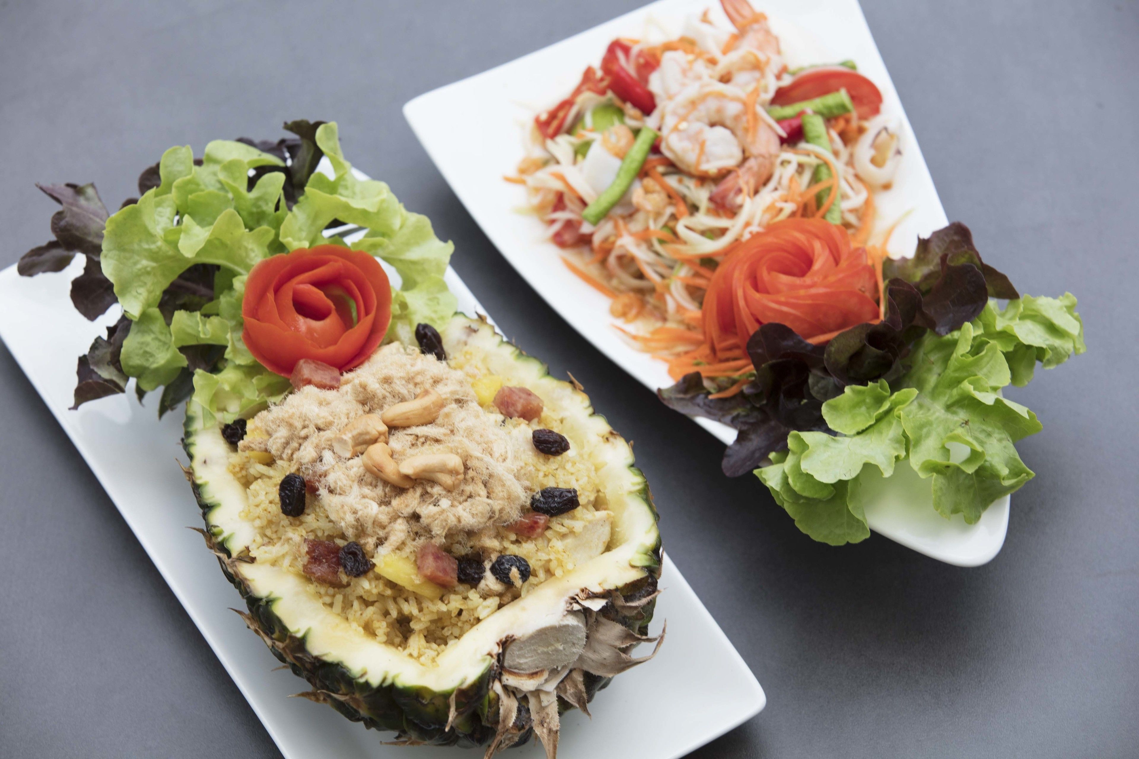 Une assiette avec un ananas farci et une salade.