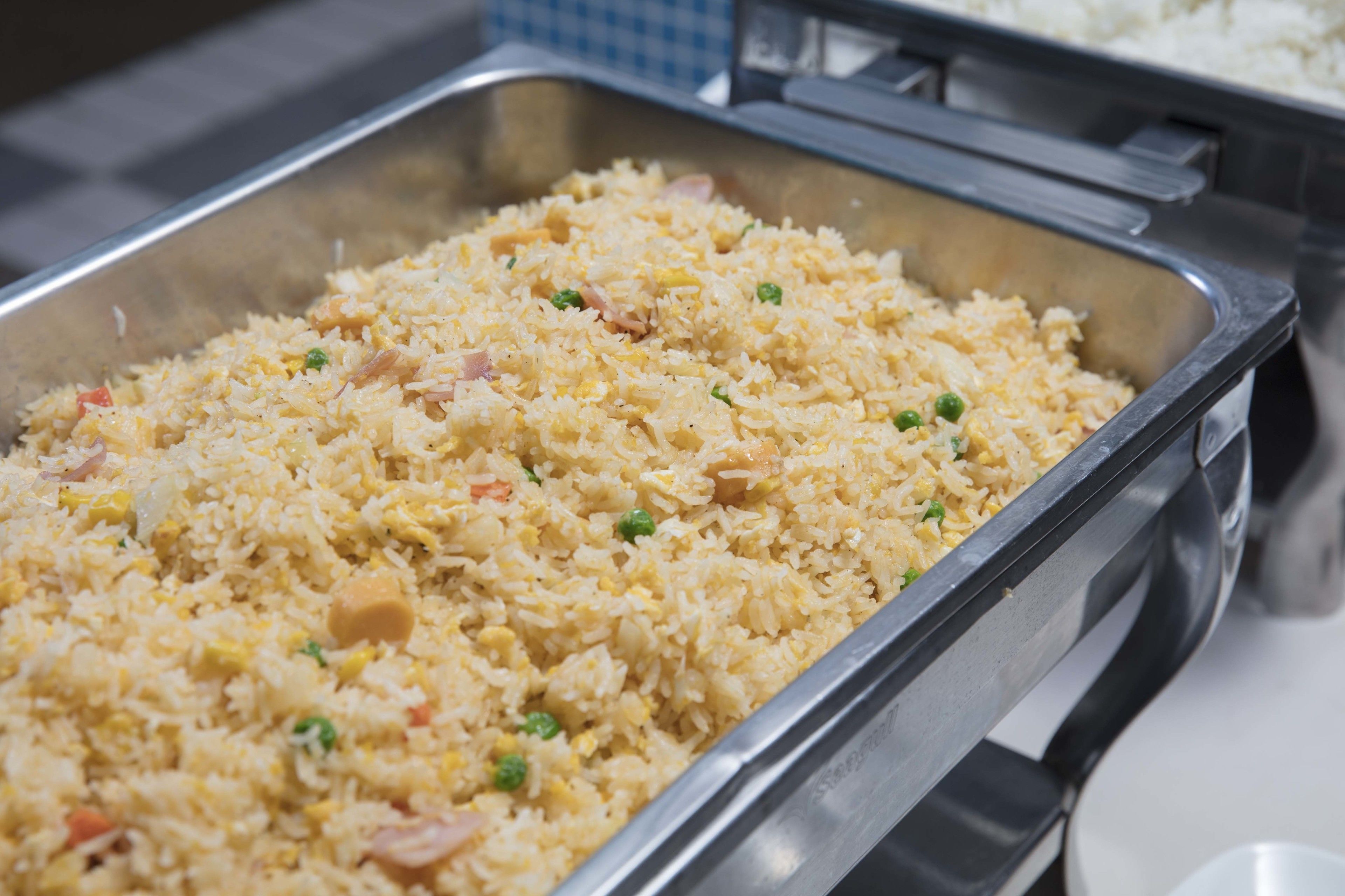 A buffet table with a large serving of fried rice.