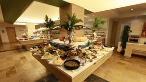 A buffet setup with various food items and decorative plants. - Turunc Resort (Marmaris)