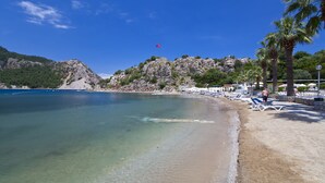 A beach with clear waters, a sandy shore, and a rocky hill in the background. - Turunc Resort (Marmaris)