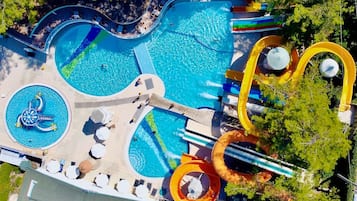 Relax by the pools, surrounded by lush trees and comfortable lounge seating.