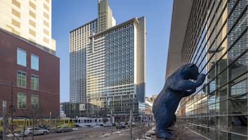 A modern building with a glass facade and a large blue sculpture in front.