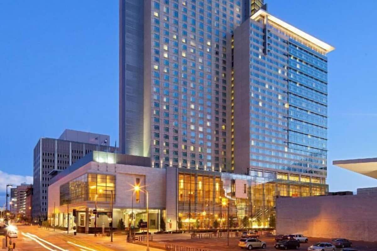 Un hotel de gran altura con fachada de vidrio moderna, varios pisos y un llamativo letrero 'HYLA'.