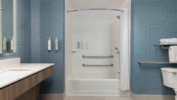 A bathroom with a shower, toilet, and vanity.