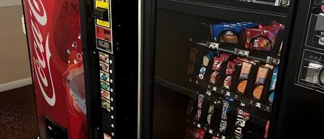 A vending machine with a Coca-Cola logo and a selection of snacks.