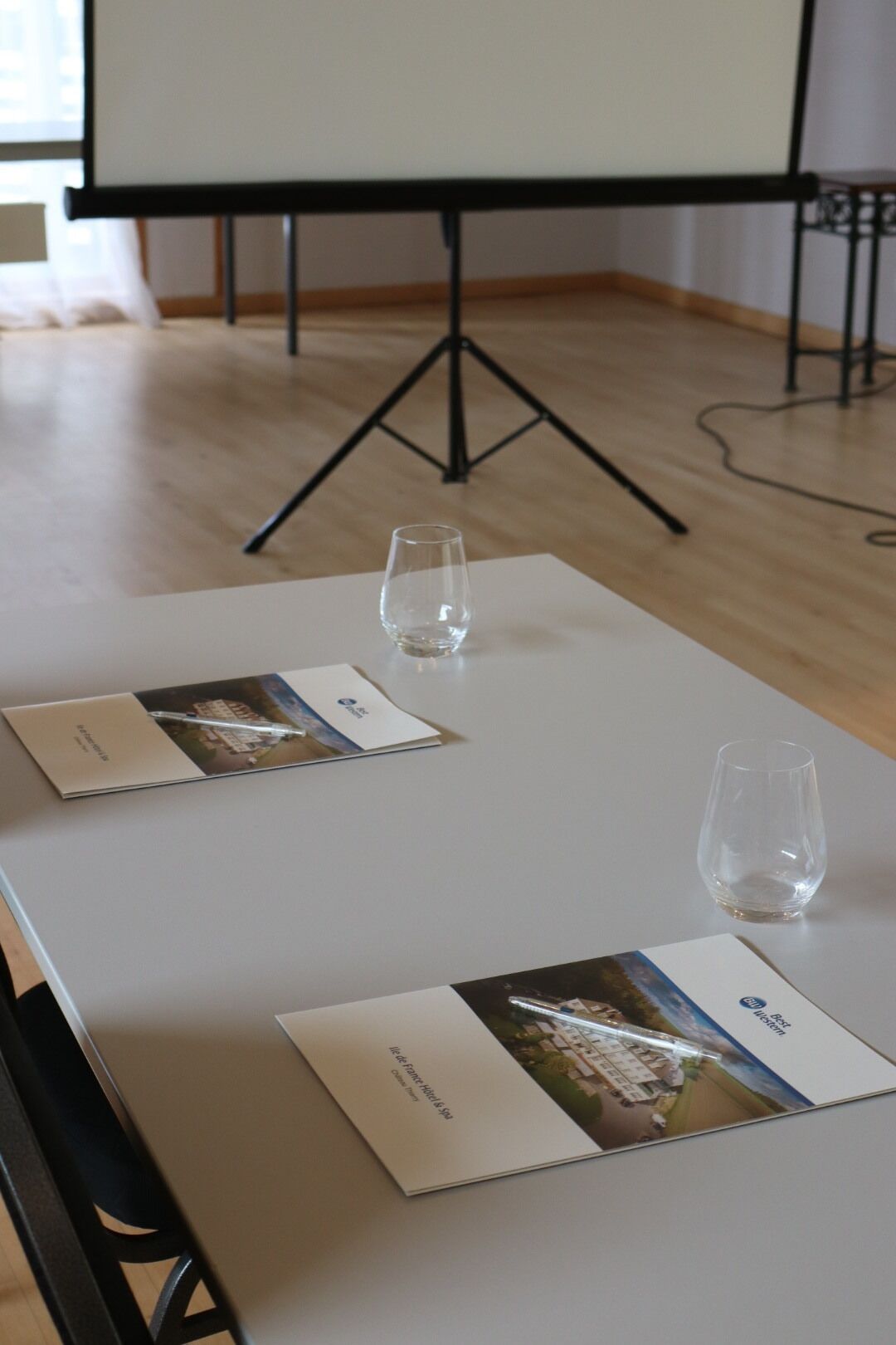 A conference table with two pamphlets and two glasses.