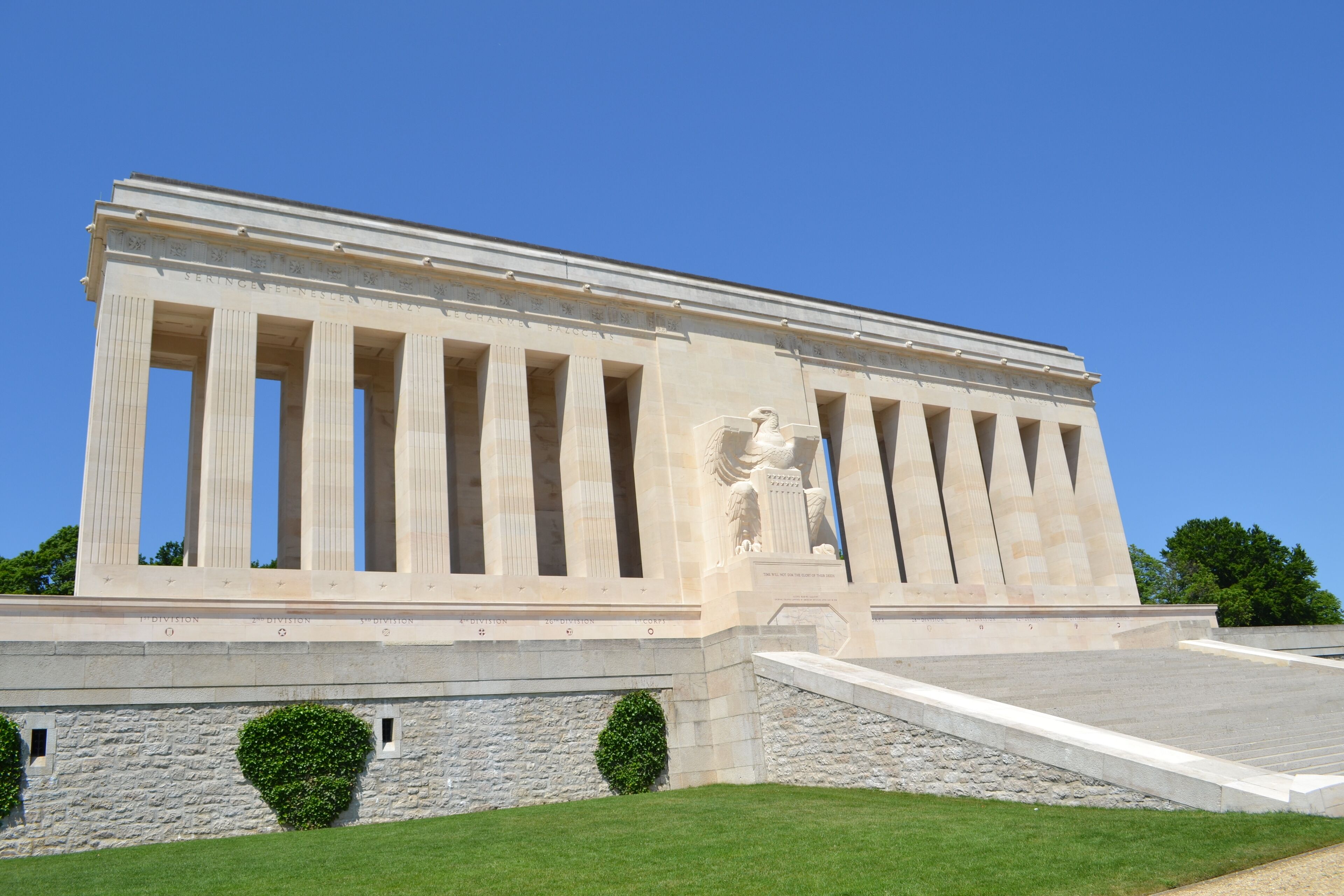 Un gran edificio de estilo clásico con una estatua destacada y columnas.