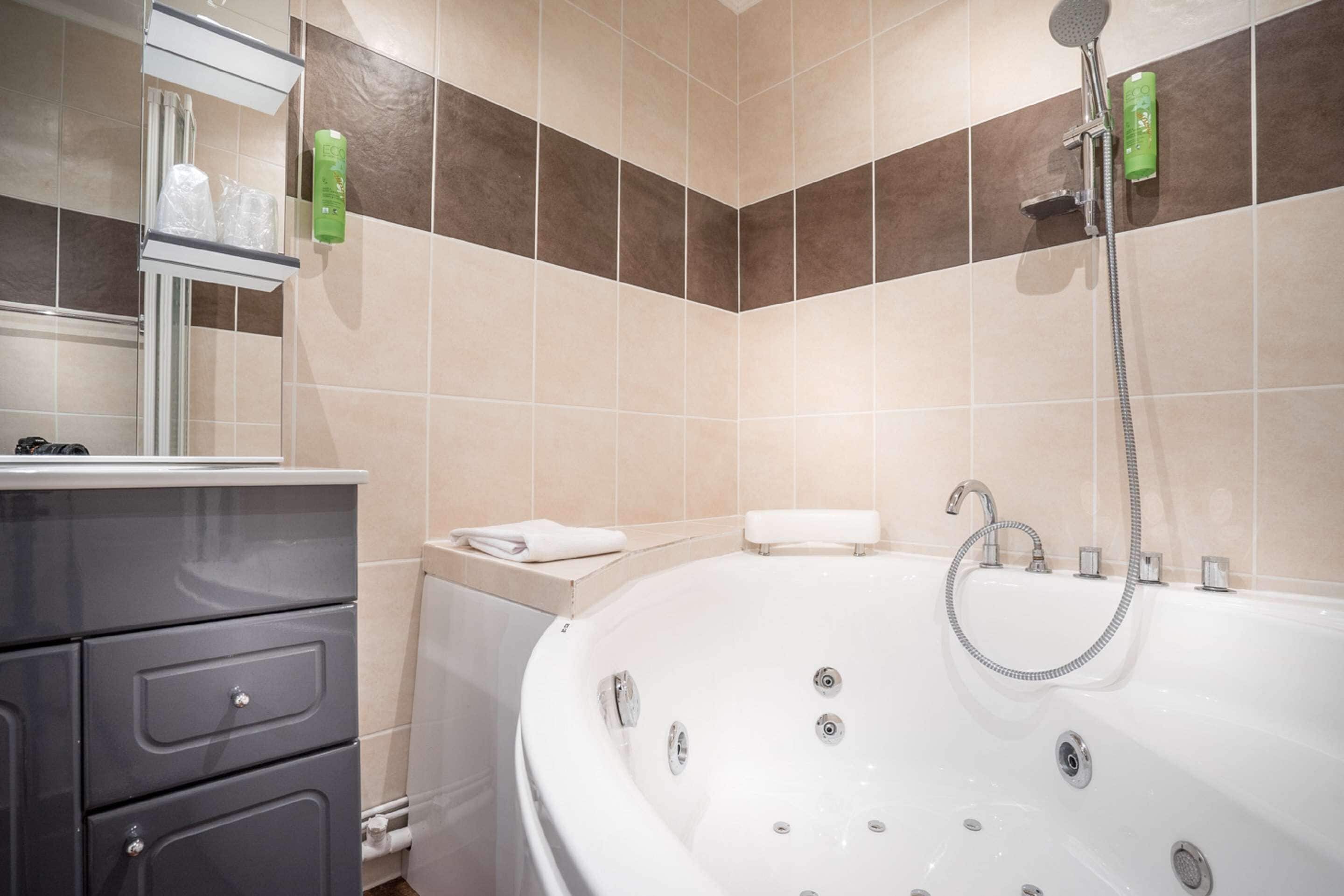Une salle de bain équipée d’une baignoire, d’une douche et d’un meuble-lavabo avec des tiroirs.