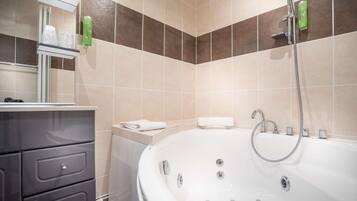 Une salle de bain équipée d’une baignoire, d’une douche et d’un meuble-lavabo avec des tiroirs.