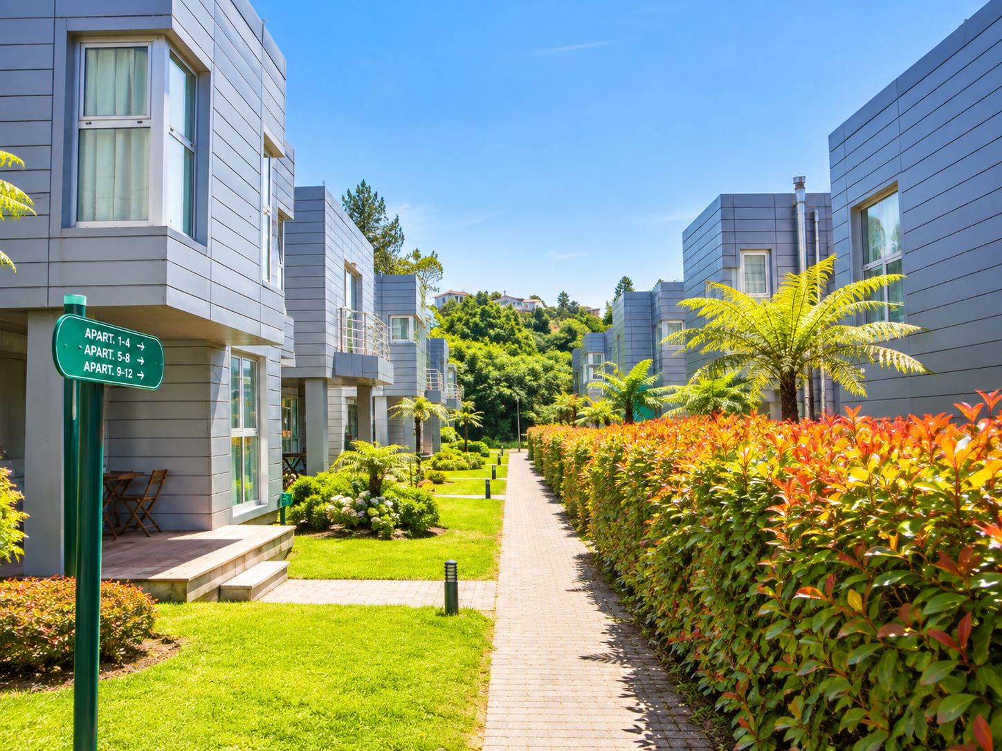 A pathway leading to a row of modern apartment buildings with a sign indicating apartment numbers.