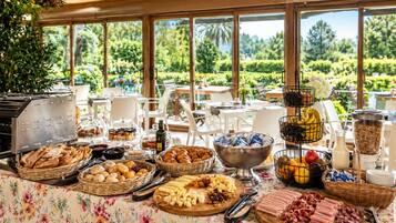 An outdoor buffet with various food items and a scenic view of greenery.